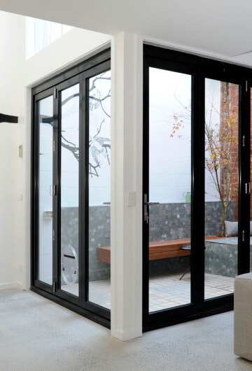 Black-framed aluminium bi-fold doors opening onto a courtyard